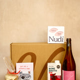 Collection of products including a bottle, box, and packages on a beige background