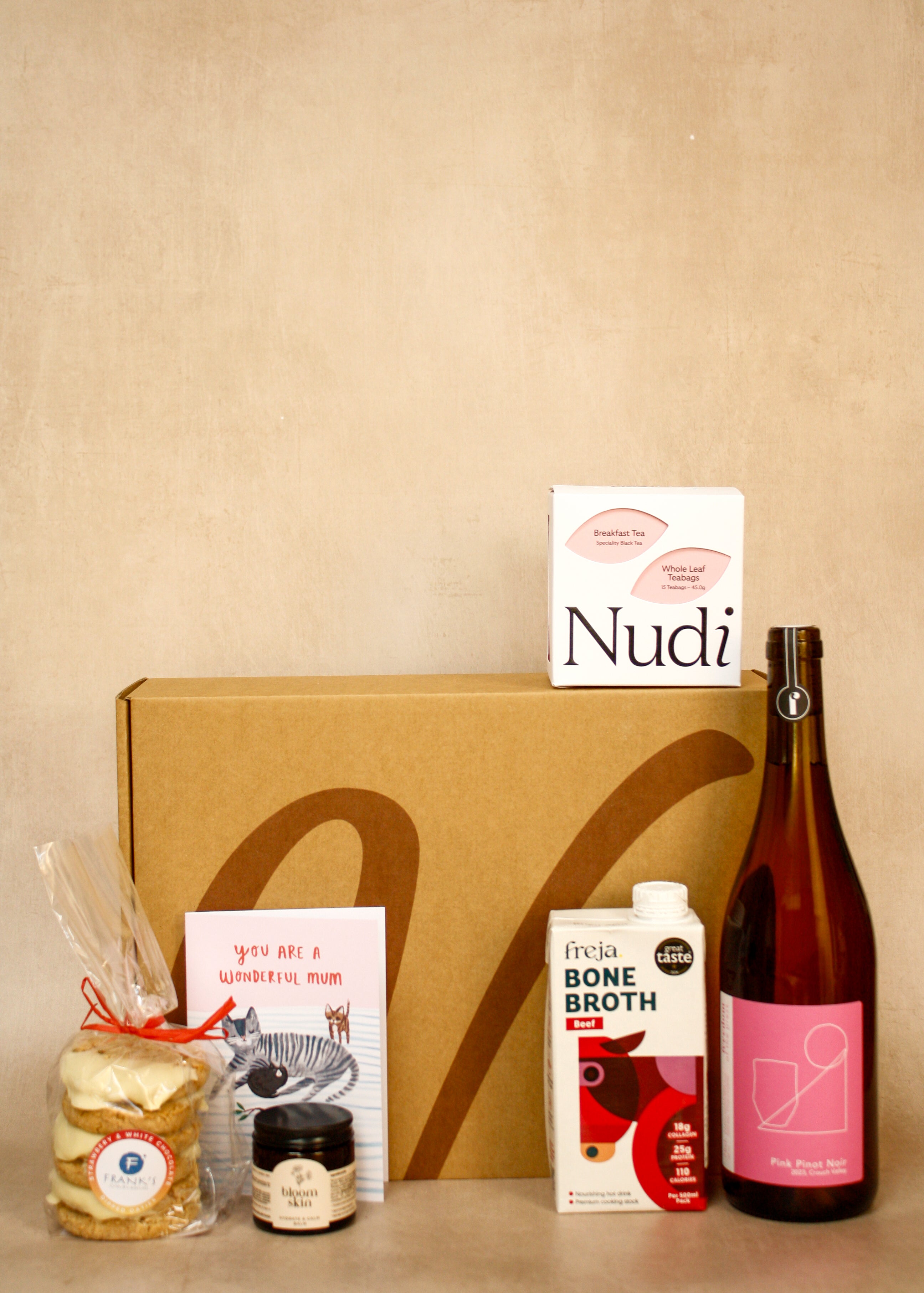 Collection of products including a bottle, box, and packages on a beige background