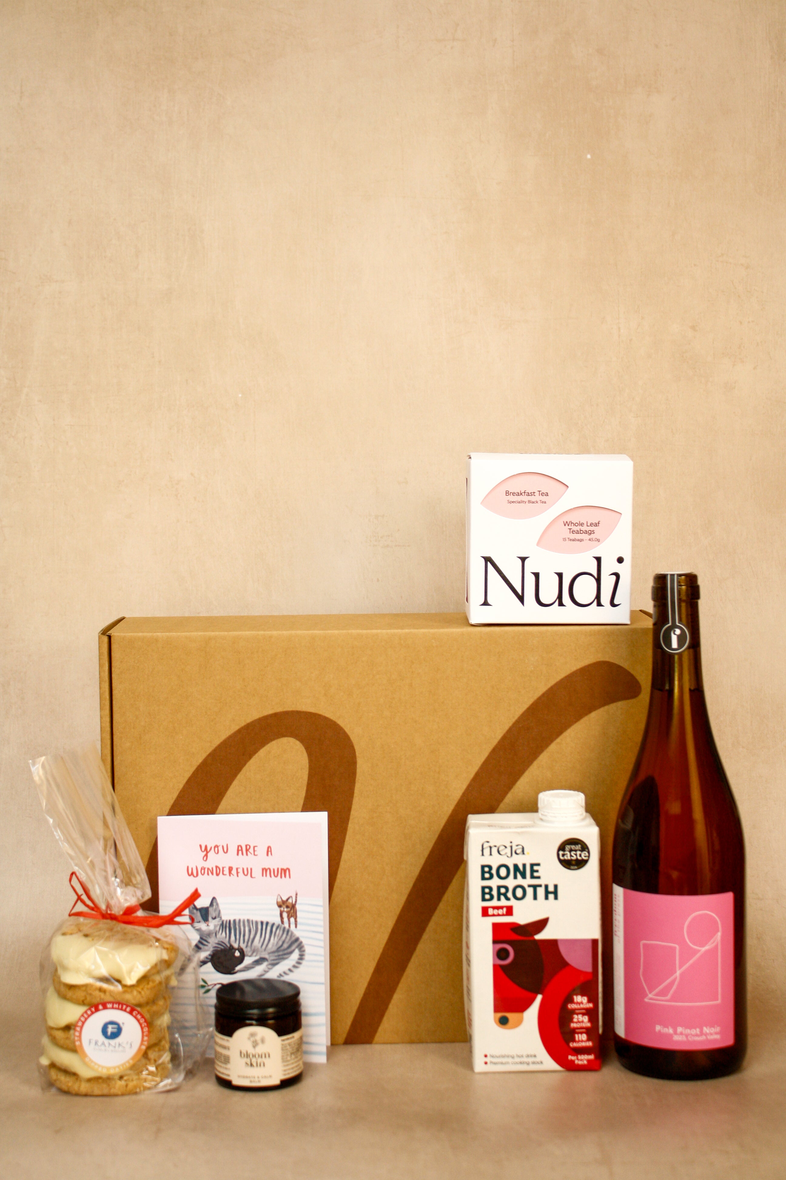 Collection of products including a bottle, box, and packages on a beige background