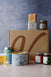 Assorted food products with crisps, a can of drink, assorted jars and soap on a textured background