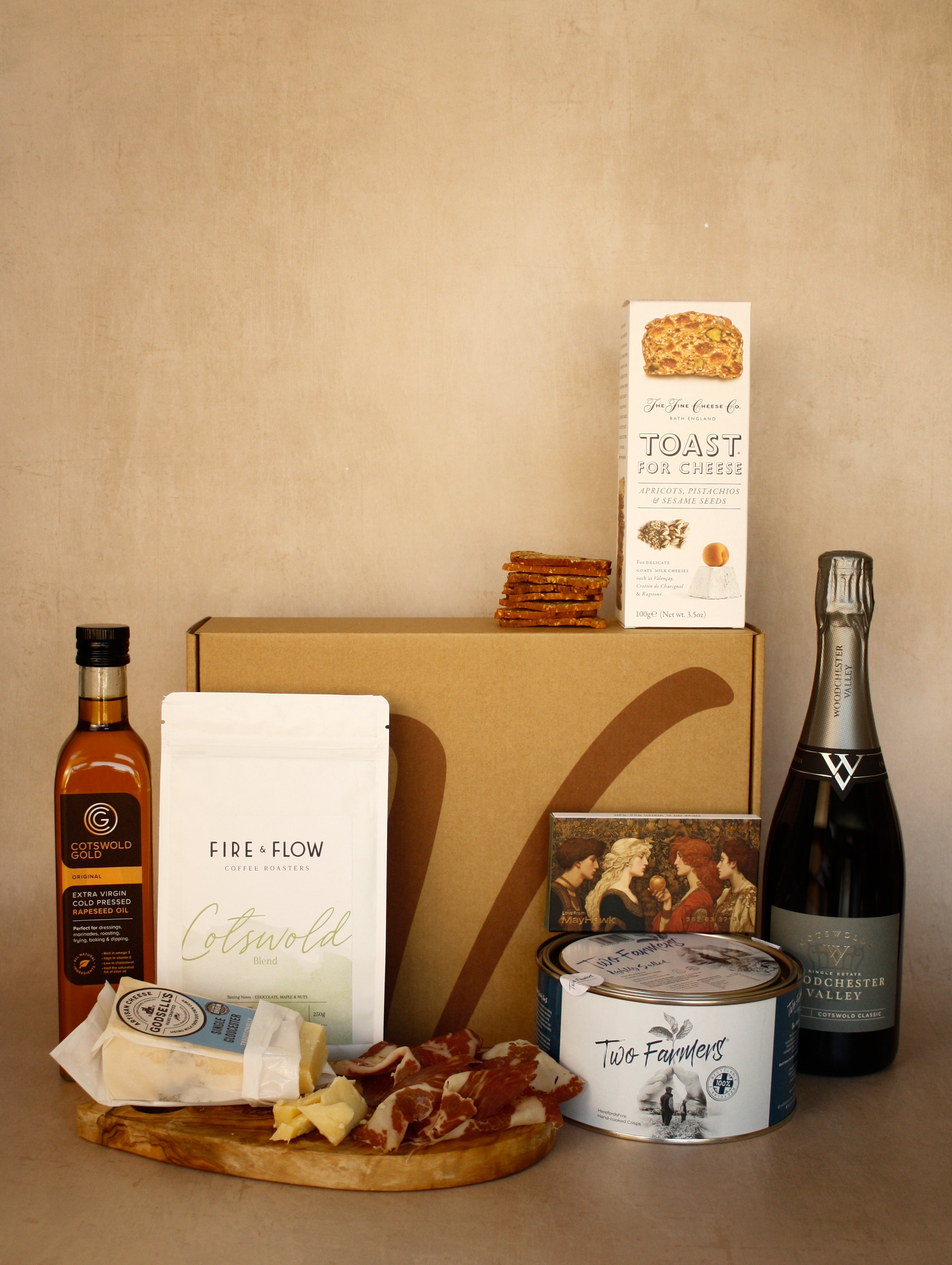 Gourmet food and wine gift set with a bottle of wine, cheese, and crackers on a wooden board.